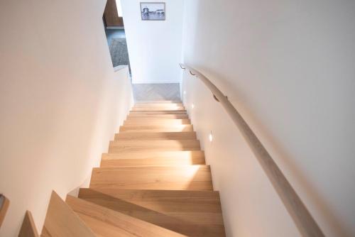 a staircase in a house with wooden floors and white walls at Varvet Sea View Suites by Ålandhotels in Mariehamn