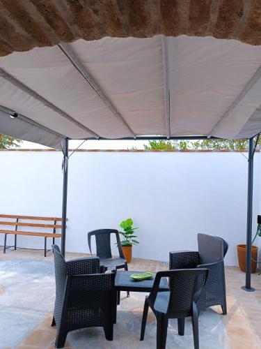 a patio with chairs and a table under a white umbrella at O Cantinho dos Avós in Carrapatelo