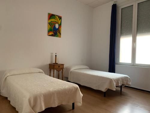 una habitación con dos camas y una ventana en Hakuna Matata Holidays, en Huelva