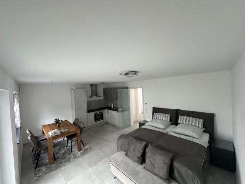 a bedroom with a bed and a table and a couch at Capri Appartement in Heßdorf