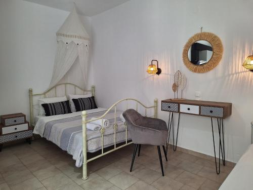 a bedroom with a bed and a desk and a mirror at Vithos in Agnontas