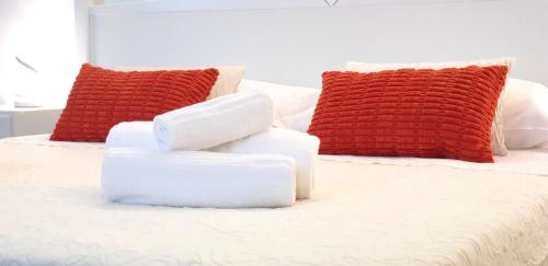 a bed with two red and white pillows on it at Sa Trunfa Rooms in Tortolì