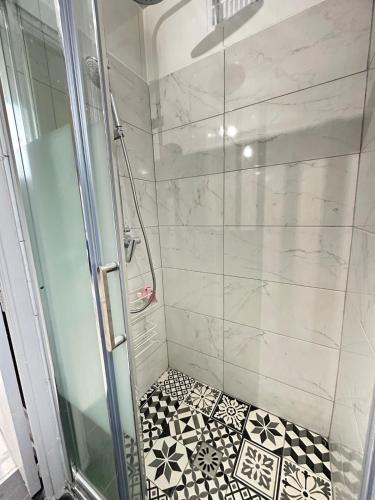 - une douche avec du carrelage noir et blanc dans l'établissement Cozy, bright apartment - Disney - private parking, à Rosny-sous-Bois