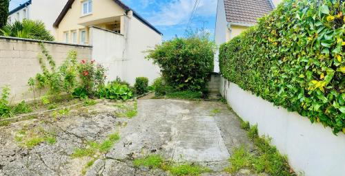 an alleyway in a yard next to a house at Cozy, bright apartment - Disney - private parking in Rosny-sous-Bois