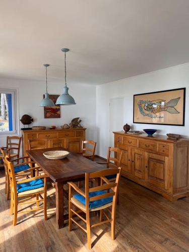 une salle à manger avec une table et des chaises en bois dans l'établissement La Bretonne vue mer, à Lanmodez