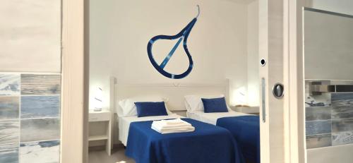 a room with two beds and a sign on the wall at Sa Trunfa Rooms in Tortolì