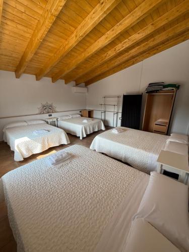 three beds in a room with wooden ceilings at VILLA RINCON DEL BUITRE in Moratalla