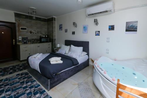 a bedroom with a bed and a tub in it at Luxury Panorama pyramids & jacuzzi in Cairo