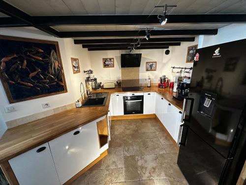 une cuisine avec des armoires blanches et un réfrigérateur noir dans l'établissement Appartement de standing au coeur de la ville, à La Rochelle