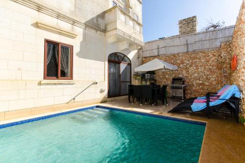 a swimming pool in the backyard of a house at Girgentina in Xagħra