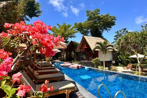 a pool at a resort with red flowers at S Resorts Hidden Valley Bali in Uluwatu