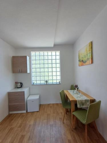 a kitchen with a table and chairs and a window at BIKER'S BASE Guesthouse in Jajce