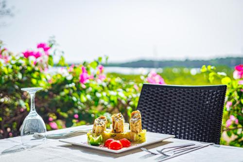 a plate of food on a table with a plate of fruit at Keur Saloum Resort in Toubakouta