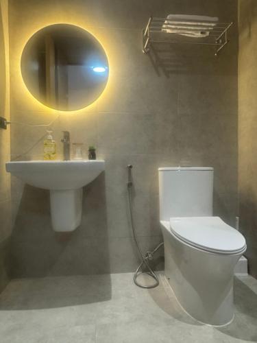 a bathroom with a white toilet and a sink at The Infinity View in Talisay