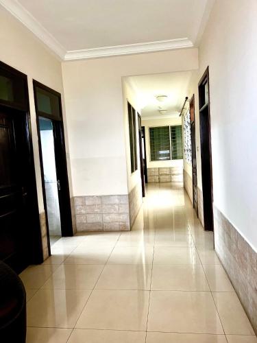a hallway of a house with white walls and a tile floor at Refined Comfort at the Right Price-Four Bedroom Luxury Apartment in Accra