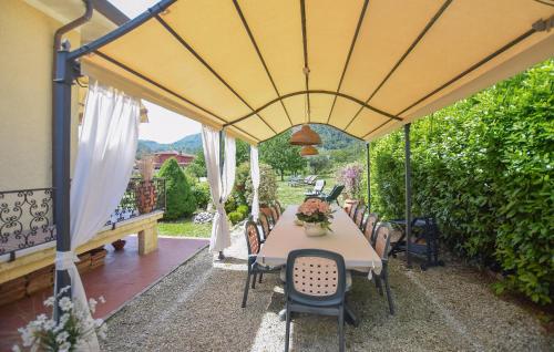 une table et des chaises sous un parasol jaune sur une terrasse dans l'établissement Stunning Home In Camaiore With Wifi, à Camaiore