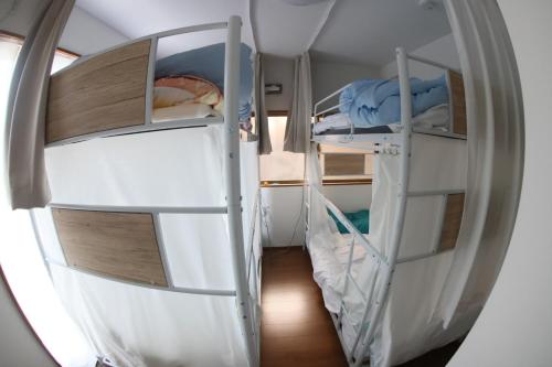 a small room with two bunk beds in it at Mount Fuji Omotenashi Guesthouse in Fujinomiya