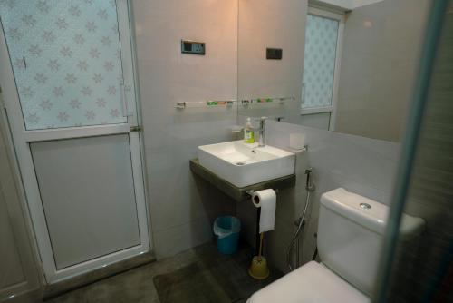 a bathroom with a sink and a toilet and a mirror at Family-friendly Private Villa with Mountain Views near Kandy in Katugastota