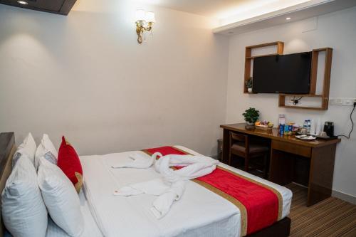 a hotel room with towels on a bed with a desk at The Air Inn Uttara in Dhaka