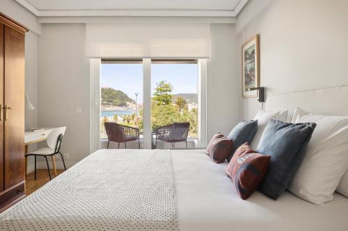 sypialnia z łóżkiem z biurkiem i oknem w obiekcie Palacio Miramar by FeelFree Rentals w mieście San Sebastián