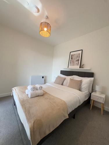 a bedroom with a large bed with a stuffed animal on it at Modern and Stunning 1 Bed near Old Trafford and City Centre in Manchester