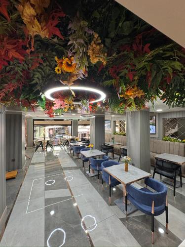 un restaurant avec des tables, des chaises et des fleurs au plafond dans l'établissement Best Nobel Hotel, à Istanbul