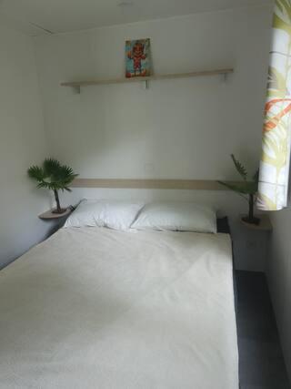 - une chambre avec un lit blanc et deux plantes en pot dans l'établissement Aureilhan Le Maori, à Aureilhan