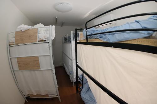 a room with two bunk beds and a closet at Mount Fuji Omotenashi Guesthouse in Fujinomiya