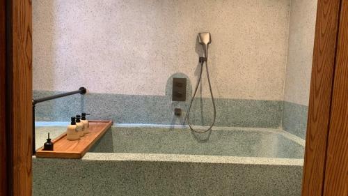 a bath tub with a shower in a bathroom at The Pink Boutique Hotel in Da Lat