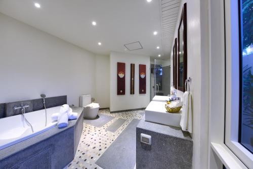 a bathroom with two sinks and a tub at Baan Rim Talay in Nathon