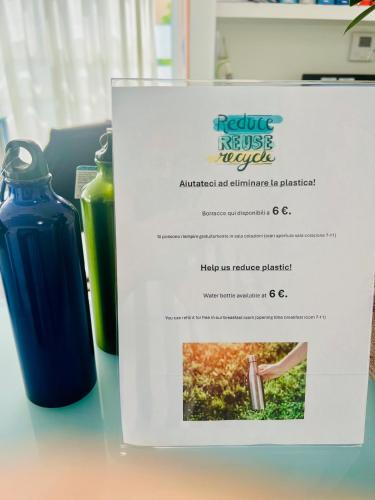 a sign sitting on a table with a bottle of liquid at L'Essenza Hotel in Olbia
