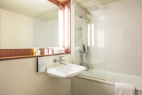 a bathroom with a sink and a shower at Campanile Rouen Sud - Cléon Elbeuf in Cléon