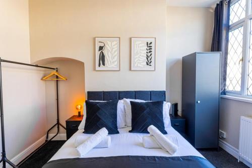 a bedroom with a blue and white bed with pillows at Wolverhampton 4 Bed home, Sleeps 7, Parking in Tettenhall