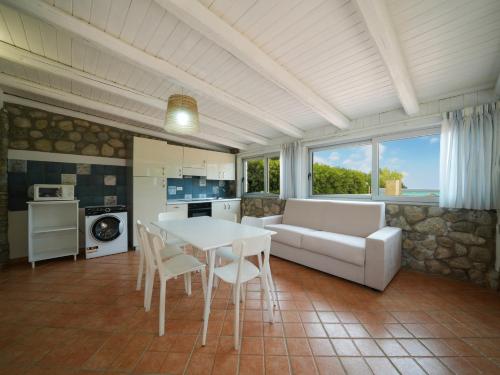 a living room with a couch and a table and chairs at Marinella Beach Apartments - On The Beach - Private Free Parking in Capo Vaticano