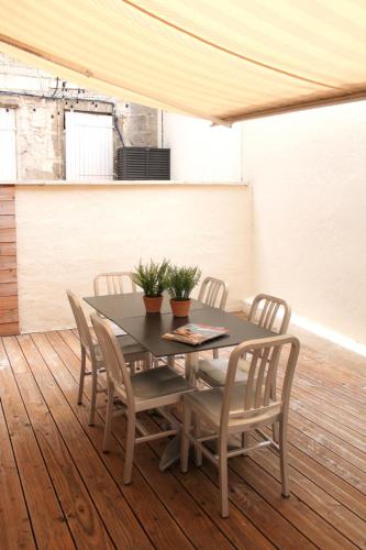 une table à manger et des chaises sur une terrasse en bois dans l'établissement Au Coeur du marché - Hyper centre Dijon - Terrasse, à Dijon