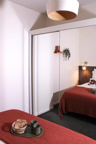 - une chambre avec un lit rouge et un mur en verre dans l'établissement Au Coeur du marché - Hyper centre Dijon - Terrasse, à Dijon
