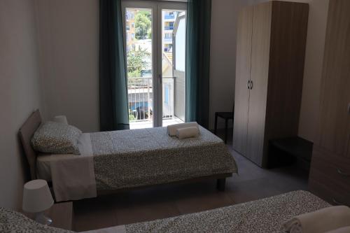 um quarto com duas camas e uma janela em Zu Pino Apartments Cefalù em Cefalù