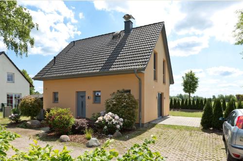 a small yellow house with a black roof at Seegasse in Göhren-Lebbin