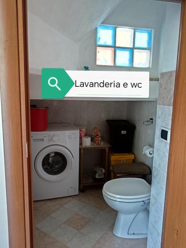 a bathroom with a washing machine and a toilet at La casa di Pina in Latronico
