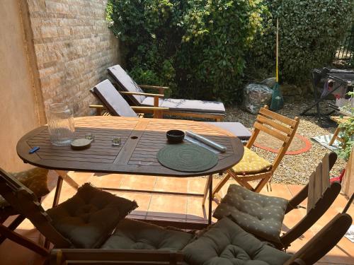 une table en bois avec des chaises et une tableastery ... dans l'établissement petite maison de vacances avec piscine dans un domaine, à Fayence