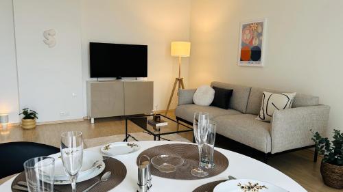 a living room with a couch and a tv at Marupe Zeltrīti Apartment in Mārupe