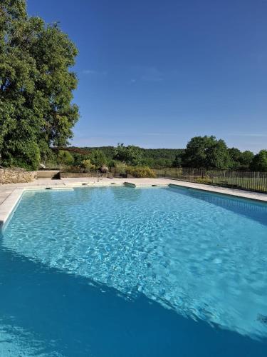 une grande piscine bleue avec une plage en arrière-plan dans l'établissement La lussanaise, à Lussan