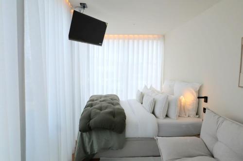a living room with a white couch and a window at Villa La Finca - Gerês in Vieira do Minho