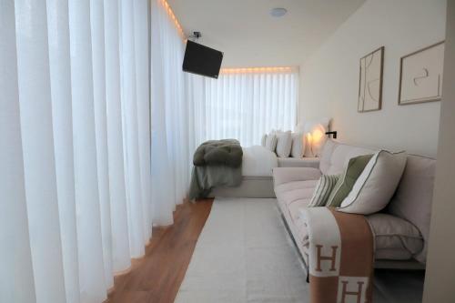 a living room with white curtains and a couch at Villa La Finca - Gerês in Vieira do Minho
