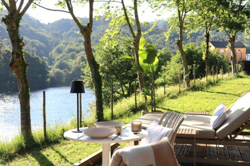a patio with a table and chairs and a view of a lake at Villa La Finca - Gerês in Vieira do Minho