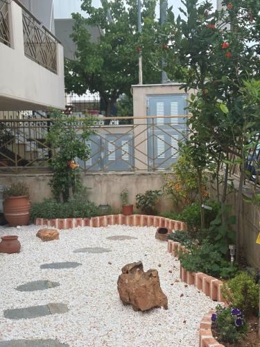 a garden with rocks and plants and a tree at 哈兰德里静谧花园套房 in Mesochórion