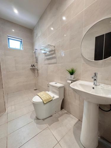 a bathroom with a toilet and a sink at MokuMoku Miri Homestay FOC Netflix & Ytb 18pax in Miri