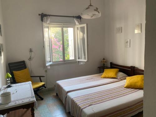 a bedroom with two beds and a window and a chair at Casa Santa Agua in Ammouliani