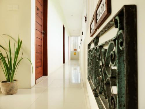 a hallway with a potted plant in a house at Arana Suite in Legian