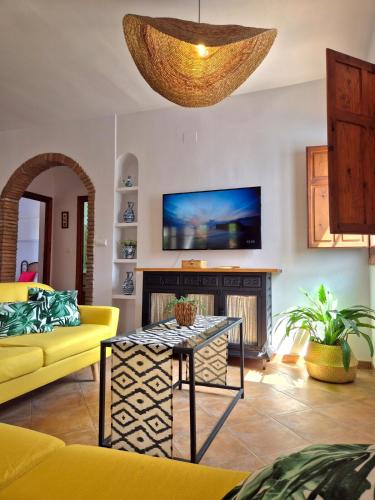 a living room with a yellow couch and a table at Villa Florida in Motril